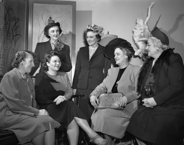 Group portrait of members of the Madison Business and Professional Women's Club. Seated left to right: Mrs. Leo R. (Helen) Mullarky, president of the Zonta Club; Dr. J. Christine Thelen, member of the medical staff at Jackson Clinic; Mrs. Charles E. (Helen) Hemingway, chairman and captain of the Dane County Branch of the Wisconsin Division of the American Cancer Society, and Miss Norma Howarth, worthy high priestess of the White Shrine Masonic organization. Standing left to right: Mrs. Ernest H. (Gertrude) Anderson, former president of the East Side Women's Club and current president of Delta Kappa Gamma, and  Mrs. William Leahy, who has served as president of the Sauk City Women's club the past seven years. The theme of the event is "Use Your Vote in '48."