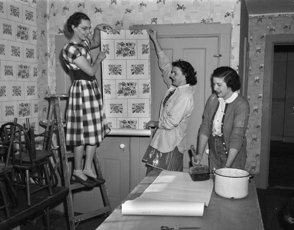 Pictured left to right are Mrs. Ted Smith, Mrs. Harry Lehman, and Mrs. William (Catherine)Gedko, members of the new Lake Edge Congregational Church, repapering the Sunday school room in preparation for the upcoming harvest festival.