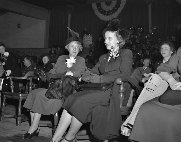 Mrs. Harry S.(Bess) Truman, at left, and her daughter, Margaret Truman, at right, seated on the speaker's platform at the University of Wisconsin stock pavilion where their husband and father, President Harry S. Truman, is giving a campaign speech. President Truman is the Democractic candidate for president in the upcoming fall election.