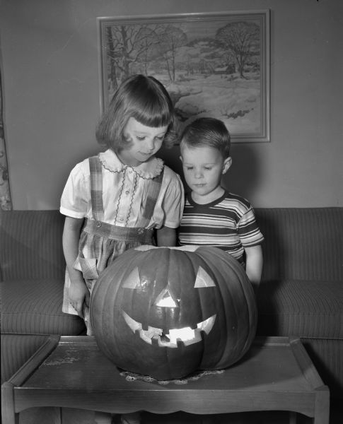 Connie and Michael Burch, children of Mr. and Mrs. Byron B. Burch, 205 South Owen Drive, with their huge pumpkin in observance of Halloween.