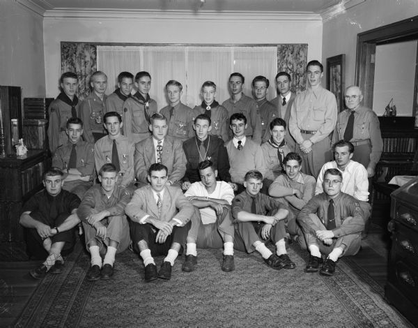 George C. Morris (last row, right) with a group of 24 scouts who have received their Eagle award from him over the past several years. This is the fourth annual dinner he has hosted at his home at 1805 University Avenue. Morris is a commissioner on the staff of the Four Lakes Council of Boy Scouts.