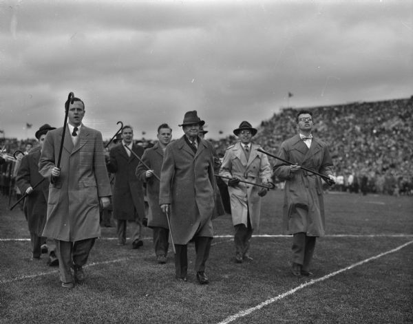 Professor William H. Page leading University of Wisconsin law school senior students in the annual cane march during half-time at the Homecoming football game.