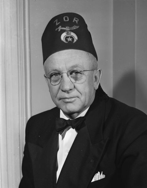 Quarter-length portrait of Governor Oscar Rennebohm wearing a "Zor" fez.
