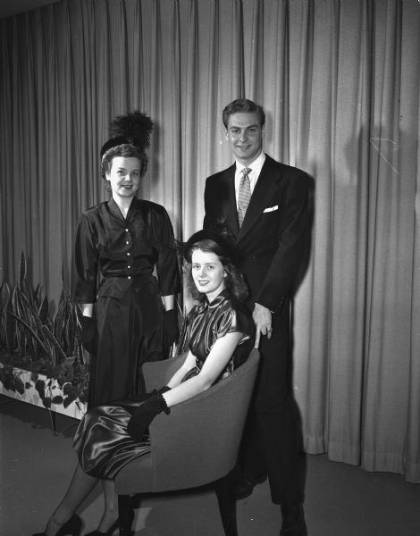 The University of Wisconsin Women's Self-Government Association sponsors a style show as a benefit for the Campus Community Chest. Three of the models are, left to right: Nancy Spiegel, Milwaukee, Howard Lapin, and seated, Charlotte Ramberg. All of the clothes were provided by a leading Madison store.