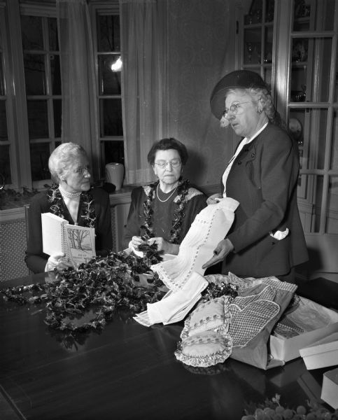 Members of the Grace Episcopal Guild prepare for their annual Christmas fair held at the church's Guild hall. Pictured left to right: Mrs. Marvin B. (Lois) Rosenberry, Mrs. W.E. Thompson, and Mrs. Edwin C. (Henrietta) Boyle.