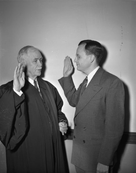 Attorney General Thomas E. Fairchild, (right) being sworn in by his father, Justice Edward T. Fairchild, of the Wisconsin Supreme Court.