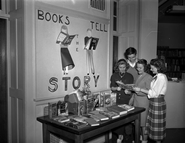 "Books Tell the Story" display at Wisconsin High School as part of the observance of National Book Week. Students looking at display are, left to right: Phyllis Berg, Gwyn Ricketts, Margie Swanson and Sally Baskerville.