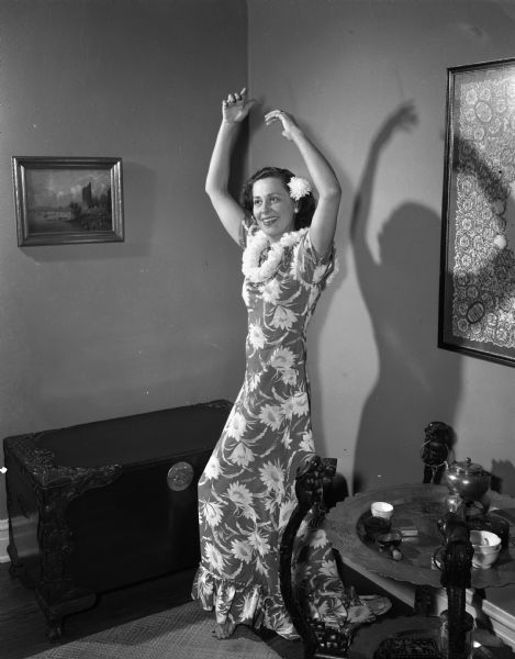Hula dancer, Mrs. Ralph (Helen) Metcalf, 3116 Crestwood Drive, in Hawaiian costume, practicing her dance routine for the Naval Officers and Wives Club Christmas dinner dance.