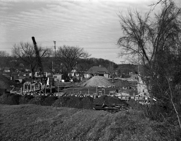 Construction scene of the Canada Dry Bottling Company building at 3396 University Avenue. Frenchy's restaurant is in the background.