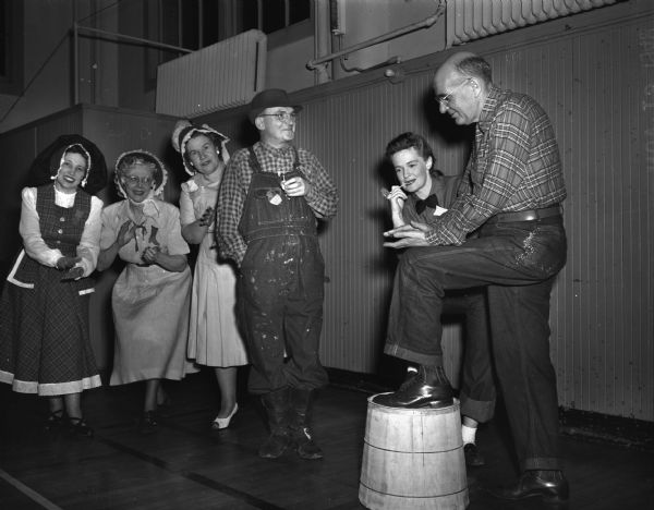 Members of the Who's New Club at a barn dance in the gymnasium of the YWCA. Three "country maidens" at left are: Mrs. M.E. Rudd, 4393 Monona Drive; Mrs. Fred Reeth (Beulah), 437 Doty St. and Mrs. Charles (Margaret) Di Renzo, 118 West Johnson Street. The "down-on-the-farmers" on the right are: Fred Reeth, Mrs. Gerald Van Winter, 3915 Meyer Avenue; and Charles Di Renzo.