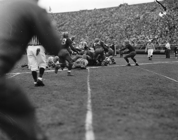 Minnesota ball carrier Stan Thiele (41) is stopped short of a touchdown by the Wisconsin defense in the fourth quarter of the football game at Camp Randall Stadium. Wisconsin players shown are Clarence Self (18), Joe Kelly (54), and John Pinnow (24).