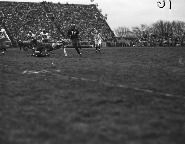 Wisconsin ball carrier Jim Embach (12) carries the ball against the Minnesota Gophers during their football game at Camp Randall Stadium.