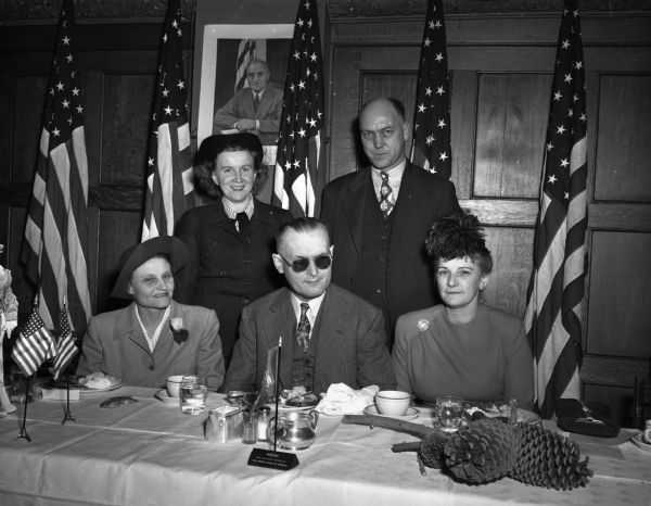 Some members at Dane County Democratic Club Victory Supper.  Seated from left to right are Mrs. Julia Boegholt, national committeewoman for the state, George Card, county chairman; and Mrs. Mabel Huffman, vice-chairman. Standing are Mrs. Ruth Doyle, new Madison assemblywoman, and George Reger, treasurer of the county club.