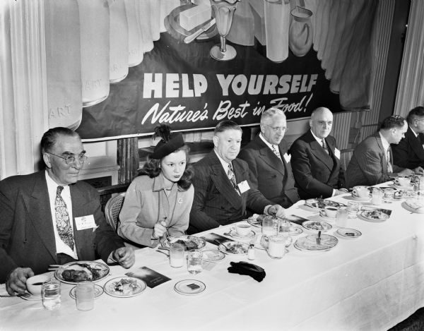 Leaders of the diary industry are shown at the dinner meeting of the American Dairy Association at the Loraine Hotel. The ADA was organized in Madison in 1938. L to R: Dr. Robert Prier, Seattle, chairman of the ADA research committee; Margaret McGuire, Wisconsin's Alice in Dairyland; W.L. Hendrix, Boise, Idaho, ADA secretary; B.F. Beach, Adrian, Michigan, chairman of the educational committee; and Pres. E.B. Fred of the University of Wisconsin.