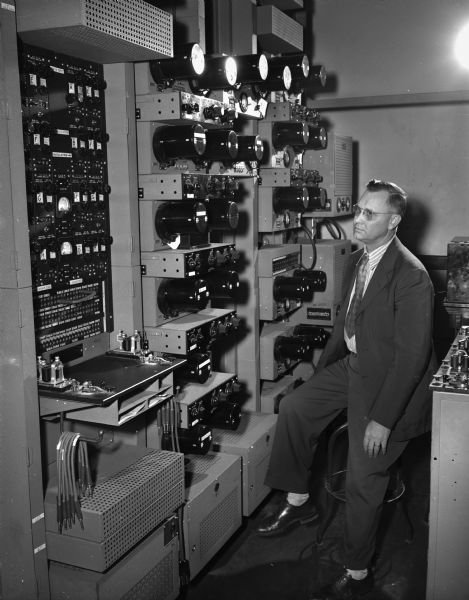 The new Western Union equipment in the Madison office which is connected with an 'electric brain' in Minneapolis, permitting faster transmission of messages. Nelson C. Sutton, supervisor of operators, is shown looking at the complicated machine."