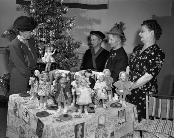 The Madison Women's Club annually dress dolls for the children at the Children's Orthopedic hospital. Admiring some of the dolls are Mrs. A.L. (Louise) Thurston, chairman of the club's social service department; Mrs. A.W. (Margaret) Ovitt, hospital chairman; Mrs. Leslie F. (Ethel) Van Hagan, president of the club; and Mrs. William (Ida) Remmel, chairman of the Orthopedic hospital committee.
