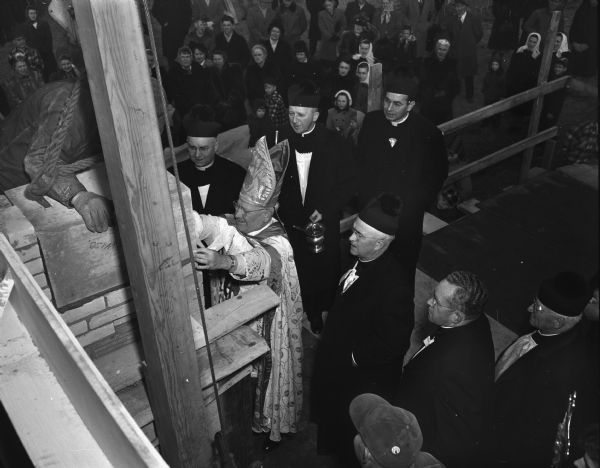 Bishop William P. O'Connor is laying the cornerstone for Our Lady Queen of Peace church and school. Flanking him are, left to right, the Very Rev. Edward N. Kinney, Chancellor of the Madison diocese, the Very Rev. F.X. Gray, Baraboo, the Very Rev. Paul Dwyer, Blanchardville, and on the bishop's left the Rev. Francis L. McCDonnell, pastor of the new church.