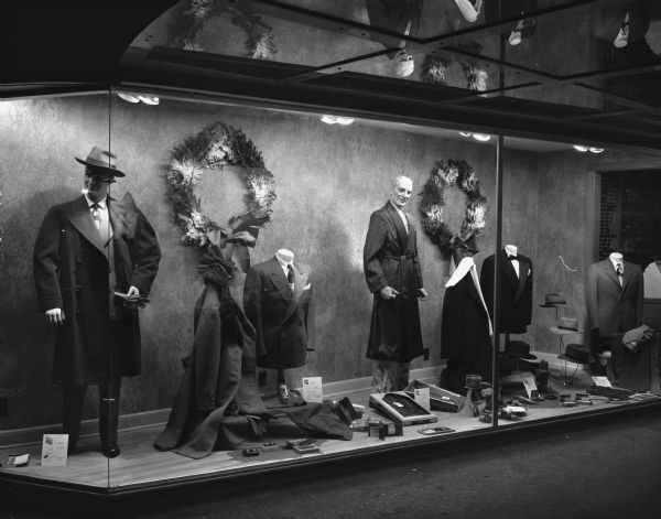 Display window at Rundell's, a men's clothing store at 15 East Main Street. The display window is decorated with Christmas wreaths. The display features various clothing items appropriate for gifts and the winter season.