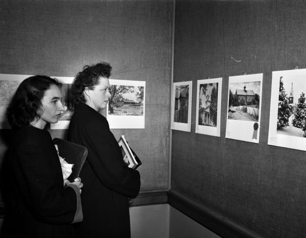 Eleanor Pascale, 819 Irving Place, and Dr. Margaret Prouty, 26 Breese Terrace, view the <i>Wisconsin State Journal</i> Photo Exhibit at the Madison Free Library.