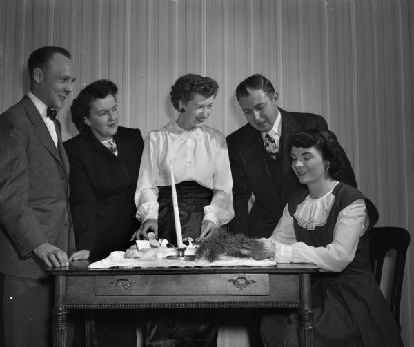 A number of Junior Chamber of Commmerce Christmas Committee members gathered around a table. From left to right they are: Robert Wegner, Mrs. Elmer Cirves, Mrs. Richard Roman, Elton Garner, and Mrs. Robert Smith.