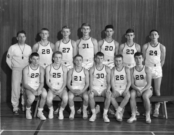 Coach Milt Diehl and the Madison East High School basketball team. In the first row are, left to right: Bob Brown, Leo Shillinglaw, Paul Nelson, Alan Hess, Ralph Jensen, and Tom McCarthy. In the back row, going right from the coach, are: Wendell Gulseth, Clarence Straaveldsen, Leo Schlicht, Tom Wippenfurth, Dean Spaith, and Ted Payne.
