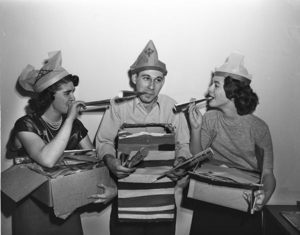 Three people, two women and one man, with noise makers preparing for a New Year's Eve party held at the LOFT. From left are Phyllis Robinson, La Vern Anderson and Joan Gottschalk. La Vern is the general chairman of the arrangements committee.