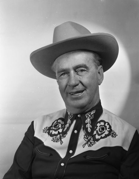 Quarter-length portrait of Joseph L. "Roundy" Coughlin in western shirt and hat.
