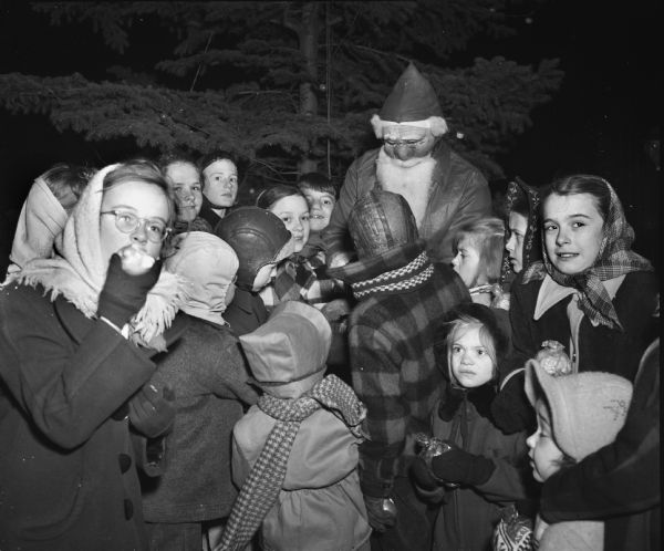 Children crowded around Santa Claus at the annual East Side community Christmas tree celebration in Riverside Park.