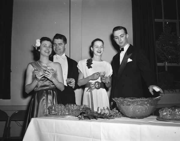Two couples at the punch bowl during the holiday benefit dance at the Turner Hall. From left are Gail Snyder, Footville; John Fox, Madison; Margot Schmidt, Madison; and Thomas R. Hefty, Jr., Maple Bluff.