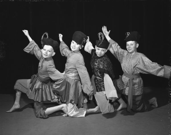 Lowell School students staged a demonstration of "Music and Dance" for educators attending the Mid-Winter music clinic at the University of Wisconsin. Four boys: David Mendenwald, Roger Skrenes, Kenneth Anderson and Richard Dyer, in Russian costumes, danced to the Nutcracker Suite.
