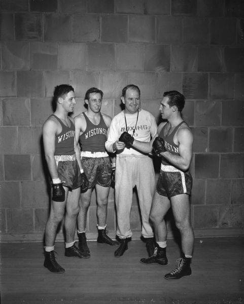 University of Wisconsin boxing coach, John J. Walsh, with three of his team boxers, brothers Dwight, Dwaine and Don Dickinson (left to right), of Tomah. Don is a national champion.