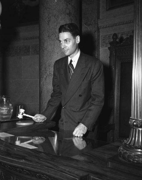 Portrait of George M. Smith, Lieutenant Governor, wielding a gavel in the Senate Chambers of the Wisconsin State Capitol at the opening of the 69th session of the Wisconsin Legislature.