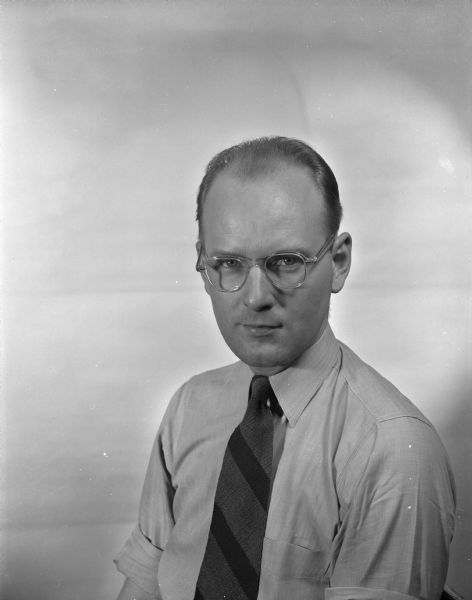 Waist-up studio portrait of Glenn E. Miller, reporter for the <i>Wisconsin State Journal</i>.