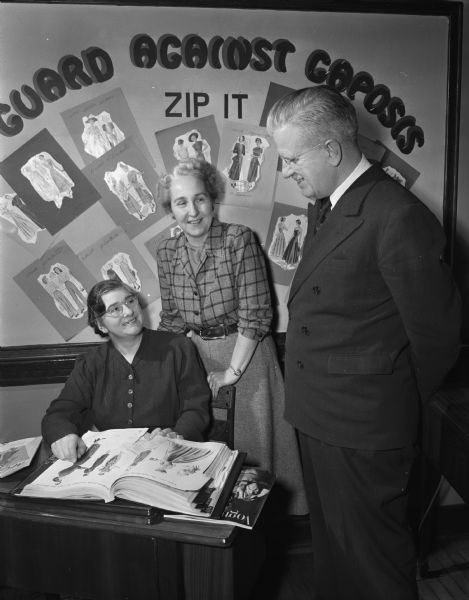 Florence Brewer, seated, from England, learning sewing from Helen John, with Richard W. Bardwell, director of Madison Vocational and Adult Education School, looking on.