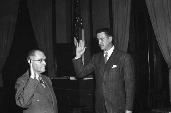 City Clerk Alf W. Bareis (right) swears in F. Halsey Kraege as mayor of Madison. He was elected by the common council to succeed James R. Law who resigned to become chairman of the State Highway Commission.
