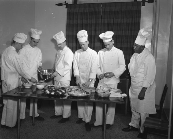 Carson Gulley, head chef at the University of Wisconsin-Madison, is shown in the refectory of Van Hise Hall with his class of apprentice chefs. Left to right: Rudy Crandall, Jim Hepola, George Gynn, Lester B. Thomas, Robert Alworth, and Carson Gulley.