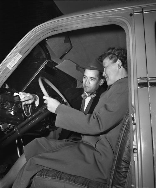 Mrs. John (Adelin) Shiels seated at the wheel of Madison Vocational School's dual control car with instructor Kenneth Davies during the school's first post-war driving course.