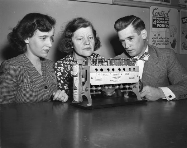 Instructor Kenneth Davies demonstrating a mock-up automobile motor to Mrs. Israel (Ruth) Zelitch and Mrs. Donald (Helen) Napper during Madison Vocational School's first post-war driving course.