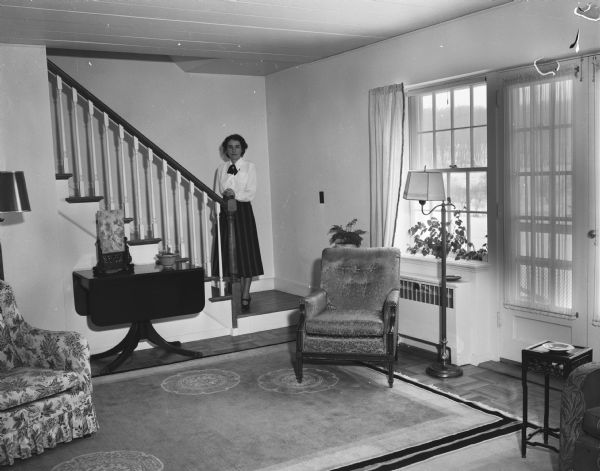 Mrs. J.E. Hurff standing on the stairway of her Eagle Heights apartment, furnished with Chinese art objects purchased during Captain J.E. Hurff's naval duty in the Orient.