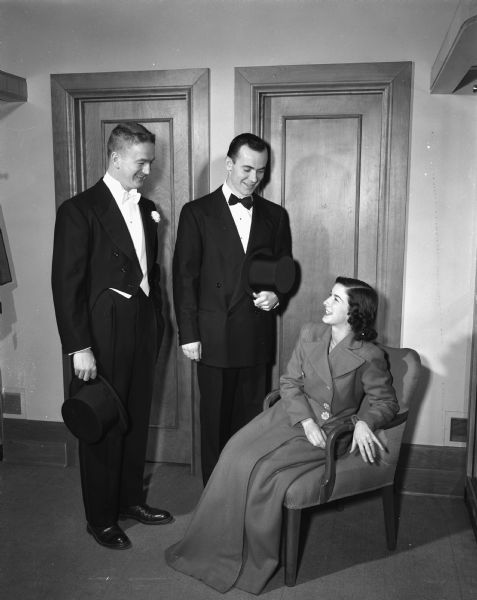 Thomas Burns in a tuxedo, Gene Adams in a suit which would be appropriate for the well-dressed prom-goer, and Mrs. Edward I. Boldon, Jr., in a formal gown, modeling the latest fashions for party-goers.
