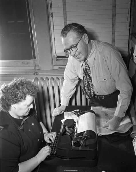 Roundy Coughlin, columnist and reporter, and Edith Goodman, his secretary, at her desk.
