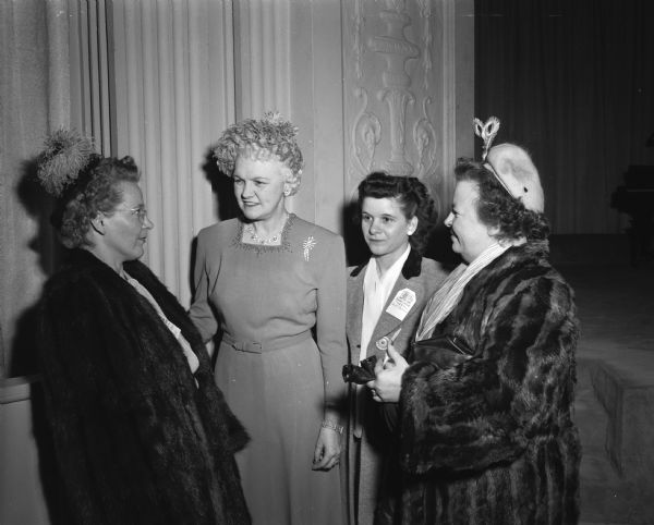 Three rural Wisconsin women meet the governor's wife, Mary Rennebohm, at a reception given by the University president and his wife for the University of Wisconsin Farm and Home Week. From left are Mrs. Martin Ruud, Phillips; Mrs. Rennebohm; Mrs. Leonard Nicoson, Troy Center; and Mrs. Edwin Blaney, rural Madison.