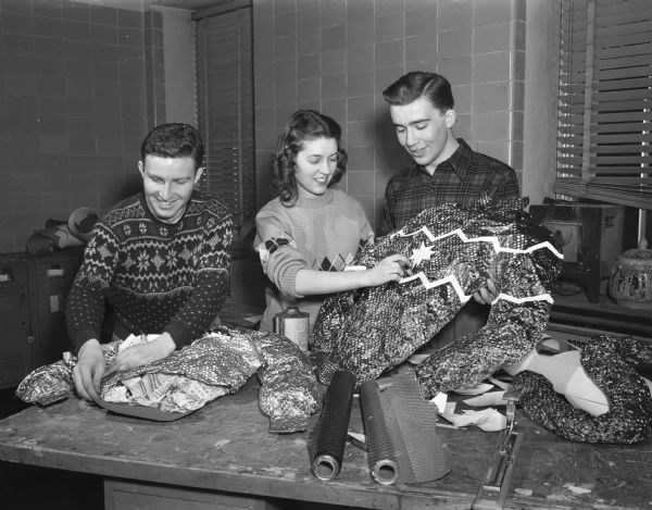 University of Wisconsin students Bob Steinhagen, Milwaukee, Connie Prentice, West Bend, and John Williams, La Crosse, making some of the elaborate decorations for Winter Carnival.