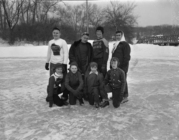 On the ice are eight Madison skaters who starred in the annual city skating meet held at Vilas Park lagoon. Kneeling in the first row are Patsy Gibson, Dennis Lange, Susanne Devine, and Phillip Oren.  Standing in the back row are Jim McFarlane, Dick Simonson, Paul Macken, and Marilyn Roth.