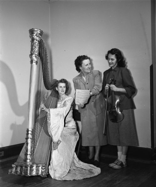 Cecile Vogelbaugh, center, director of music for the production of Phi Beta's "A Combine of Comedy," is consulting with Beverly Ethun, 202 Dunning Street, harpist, and Mary Lerdahl 2401 Center Avenue, violinist.