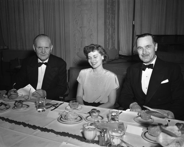 Three attendees at the University of Wisconsin Centennial Birthday Banquet held in the Great Hall of the Memorial Union. From left are John Berge, executive secretary of the Wisconsin Alumni Association; Mary Markham, Janesville, president of the Women's Self-Government Association of the Madison campus; and Don Anderson, publisher of The "Wisconsin State Journal" and director of the Dane County Centennial Fund campaign.
