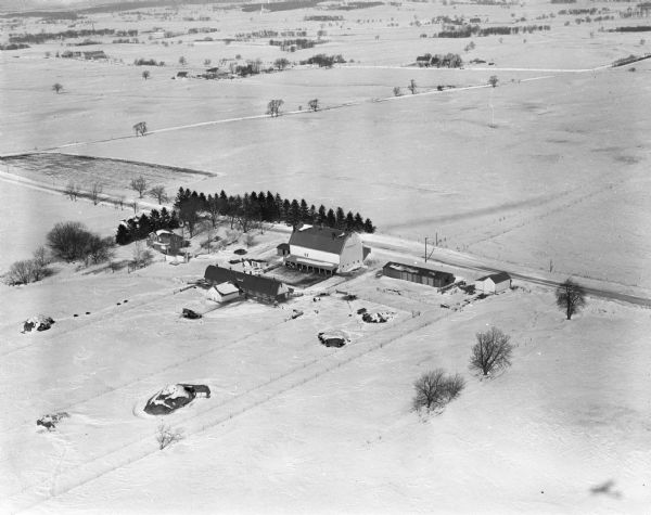 Three aerial views of the John Fluckiger farm and farm buildings amid snow-covered fields near Verona, operated by son Ivan Fluckiger.