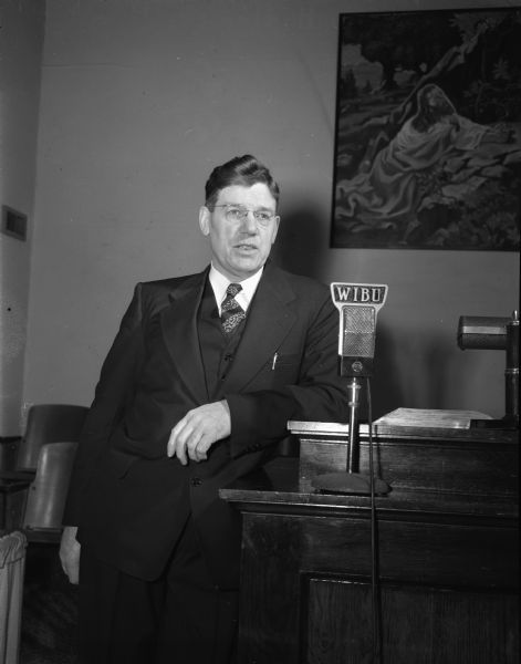 Unidentified minister at pulpit equipped with WIBU microphone. One of four images of different ministers.