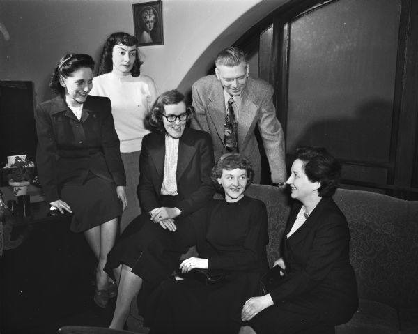 Group portrait of the Madison Vocational School French class discussing French customs with their teacher, Mrs. Erwin H. (Lucy) Ackerknecht, , seated at far right. Seated left to right are: Mrs. John (Angeline) Salerno; Isabelle Welch; Mrs. Clifford McCarthy, and Mrs. Ackerknecht. Students standing are Miss Doris Crandall, at left, and Ruben Imm, at right.