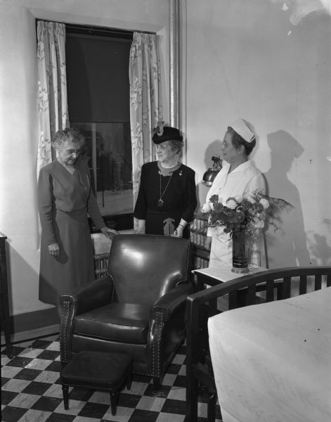 Madison Altrusa Club members inspecting a Madison General Hospital room which is maintained by the club. Left to right: Alfreda Fauerbach, 901 Jenifer Street, chairman of the Altrusa Club's hospital fund; Fanny Steve, 1710 Kendall Avenue, committee member; and Grace Crafts, superintendent of the hospital.
